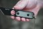 TOPS ALRT XL-03 compact fixed blade knife featuring a black utility blade with a durable angular tip and black canvas micarta handles.
