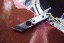 TOPS ALRT XL 03 compact fixed blade knife featuring a black utility blade with a durable angular tip and black canvas micarta handles.