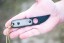 TOPS ALRT XL-05 compact fixed blade knife featuring a black hunter's point blade shape and black canvas micarta handles.