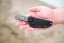 TOPS Desert Son compact fixed blade knife featuring a black recurve blade with jimping and a layered, light-toned ergonomic Black Linen Micarta handle.